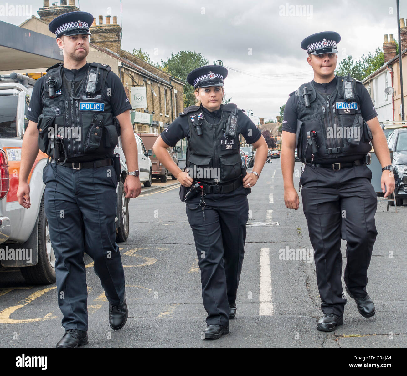 Pattuglia di polizia poliziotta e due poliziotti a piedi in strada Foto Stock