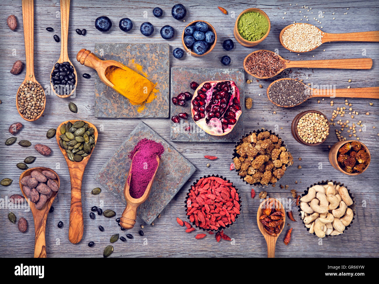 Super Foods in cucchiai e bocce su uno sfondo di legno Foto Stock Super Foods in cucchiai e bocce su uno sfondo di legno Foto Stock