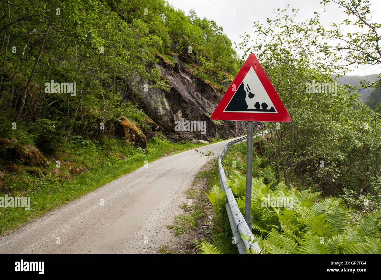 Le rocce che cadono segno di avvertimento dalla stretta stradina di montagna, Hjølmo Valley, Norvegia Foto Stock