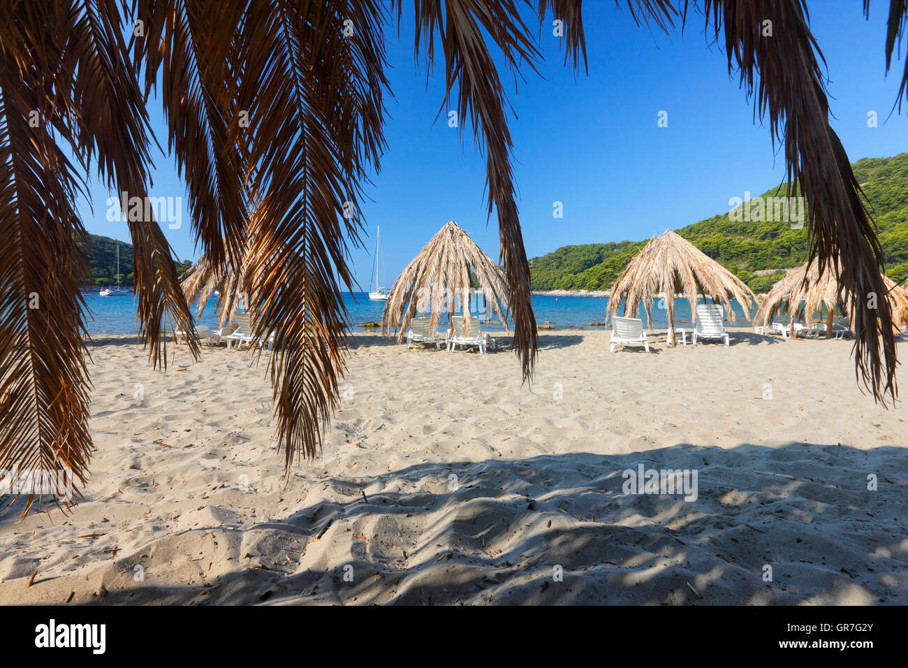 Ombrelloni di paglia in Saplunara spiaggia di sabbia sulla isola di Mljet Foto Stock
