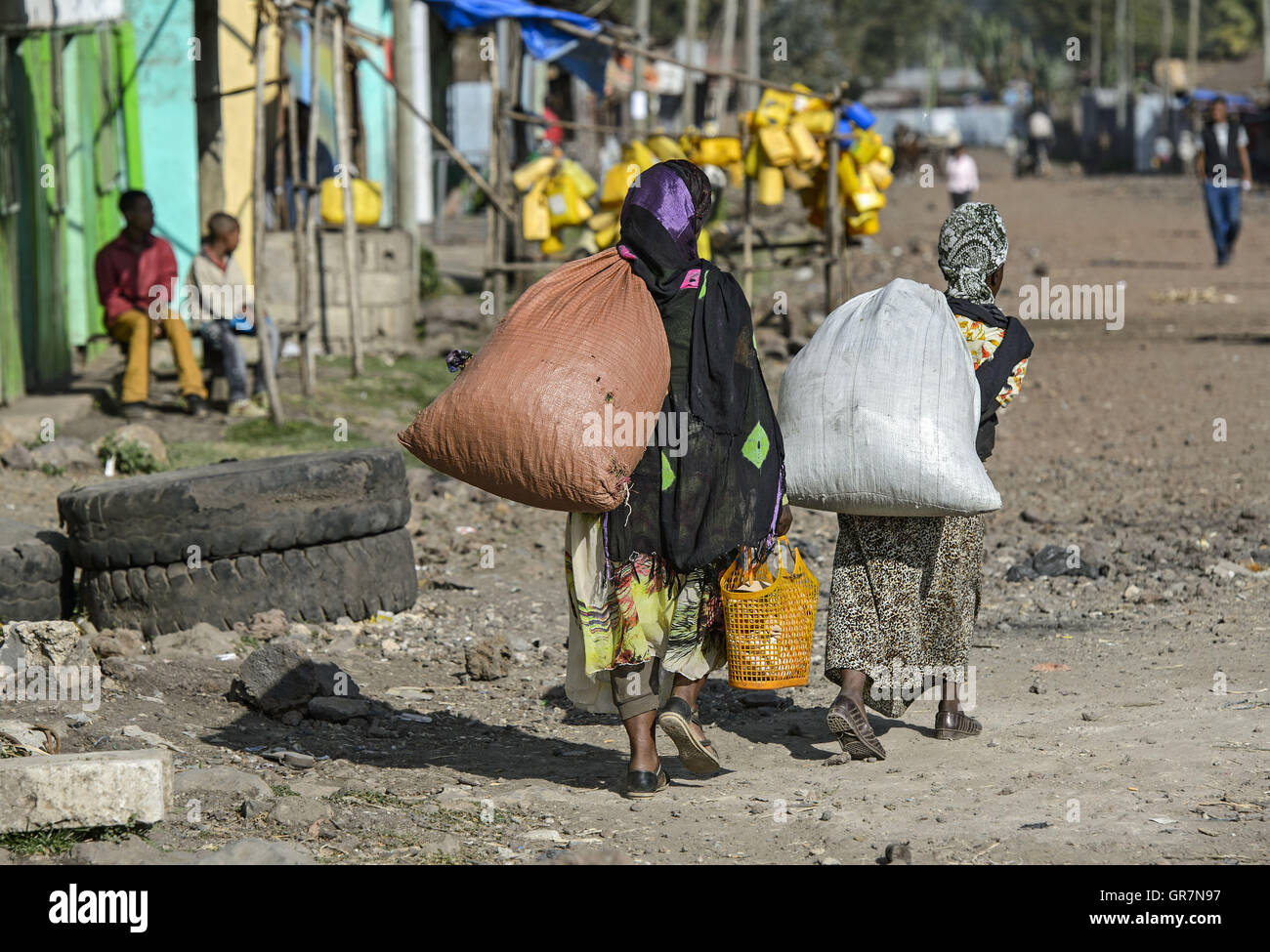 Due donne con borse pesanti sulla strada per il mercato locale a Goba, Regione di Balla, Oromiya, Etiopia Foto Stock