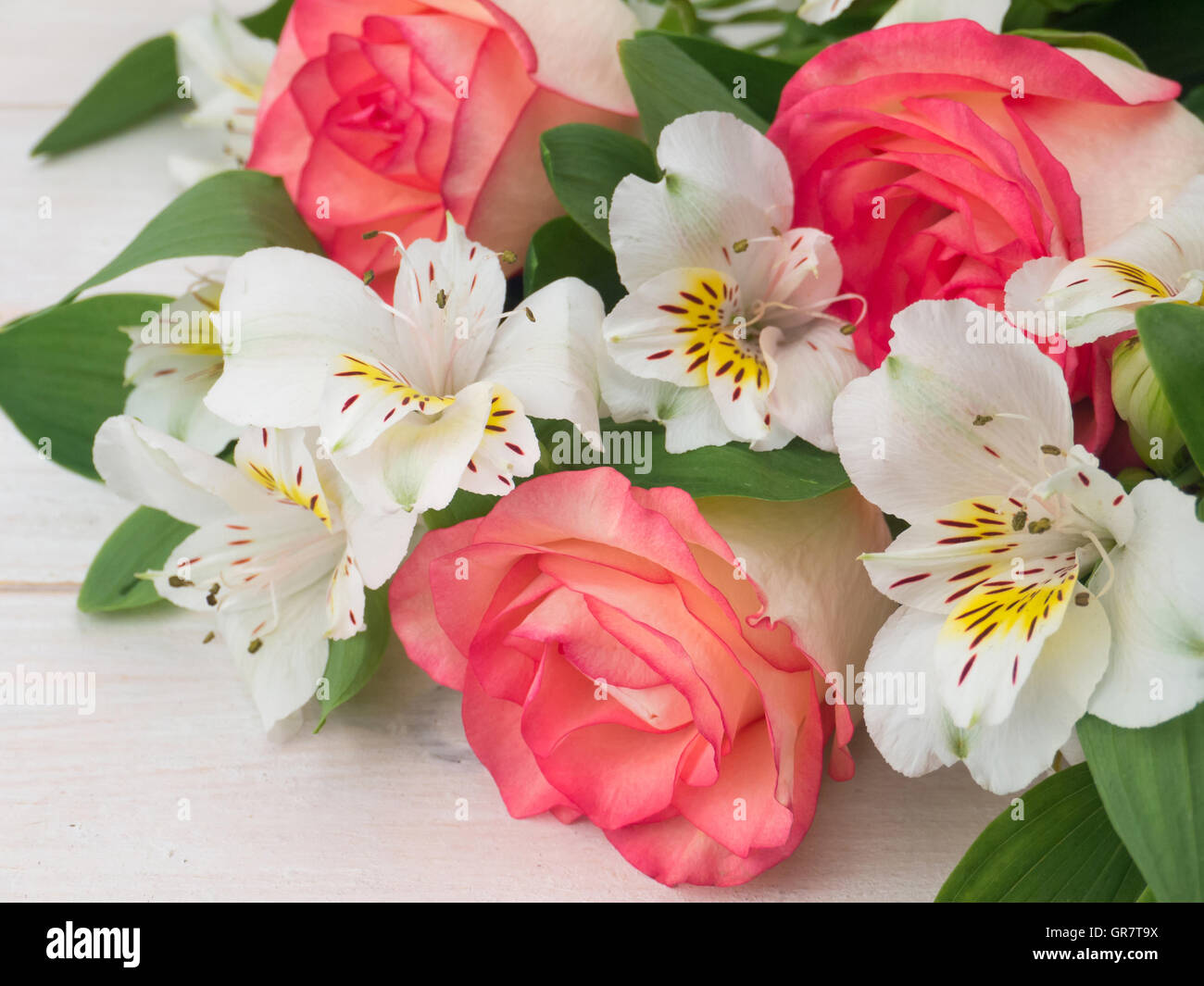 Rose di salmone e delicato alstroemeria bianco mazzetto sul bianco doghe in legno Foto Stock