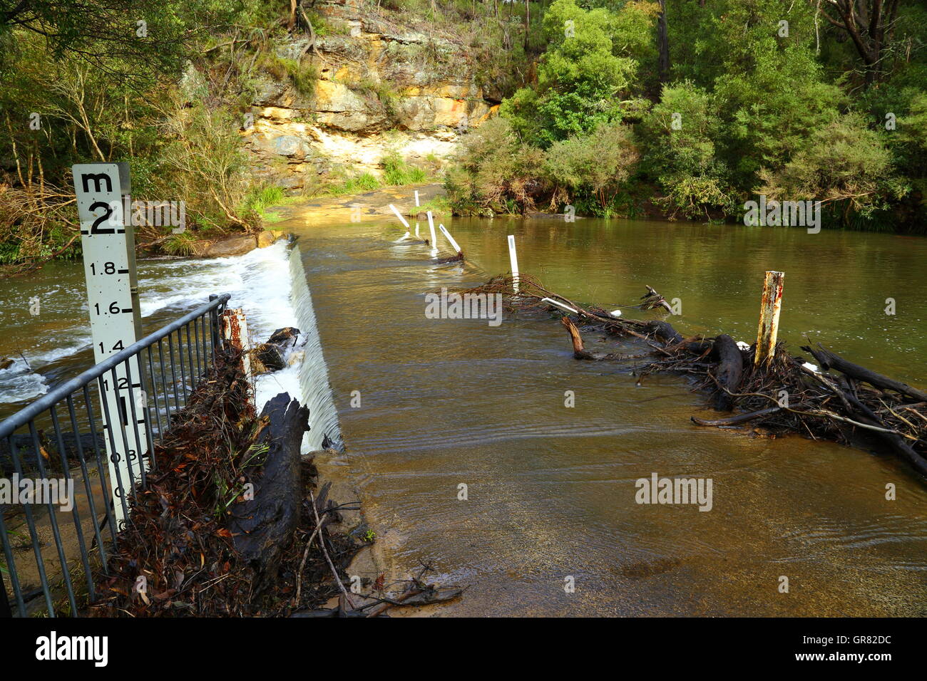 Inondati Road attraversando un torrente attraversato a Belmore Cade vicino a Robertson, NSW, Australia. Foto Stock