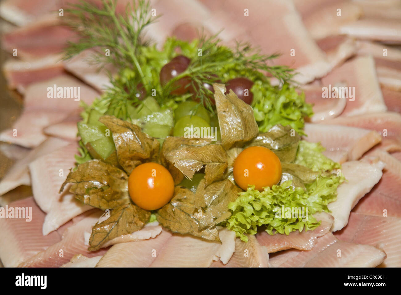 Piatto con Trota Affumicata filetto guarnita con insalata e Physialis Foto Stock