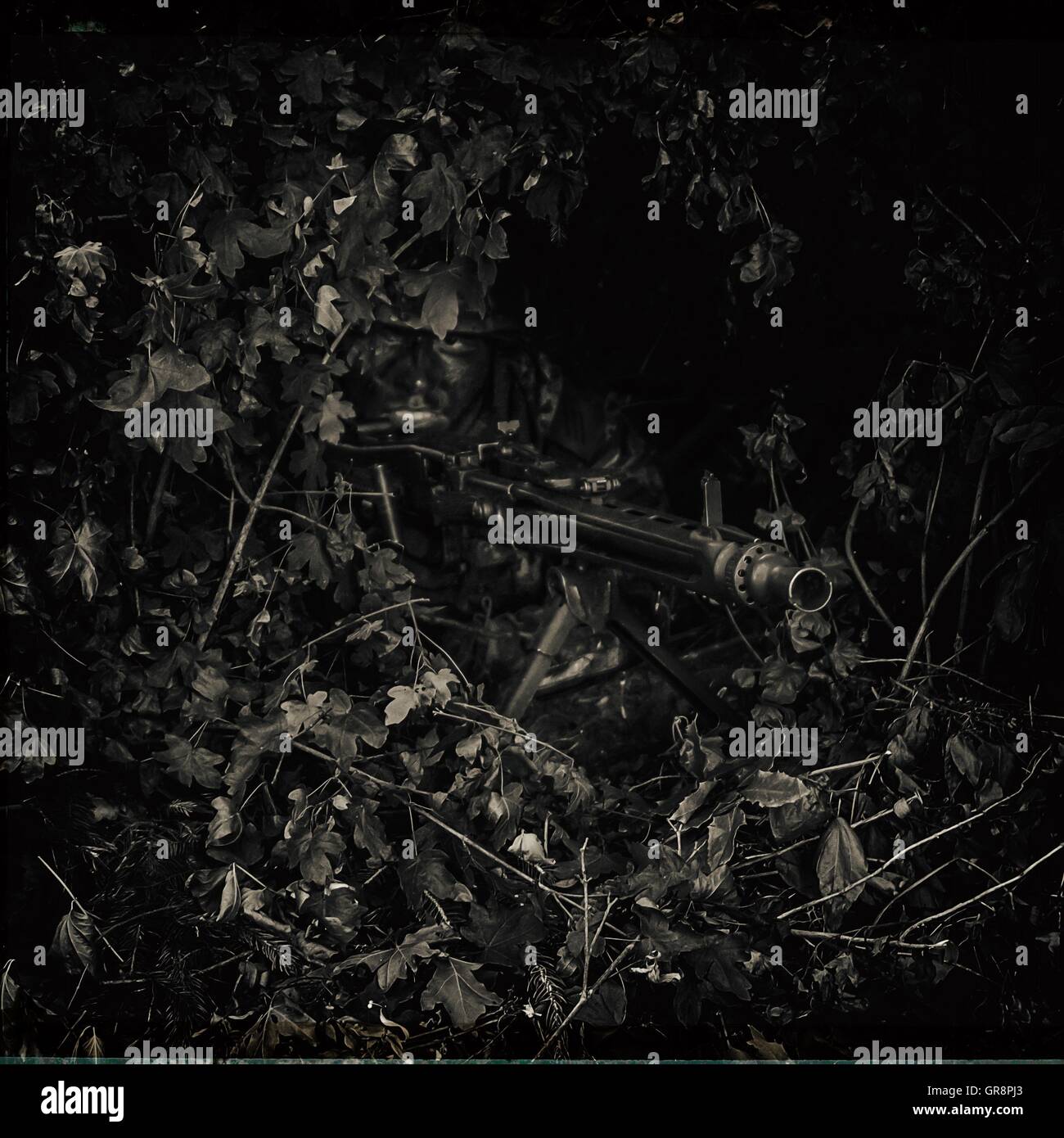 Mimetizzati soldato nelle boccole con la mitragliatrice Foto Stock