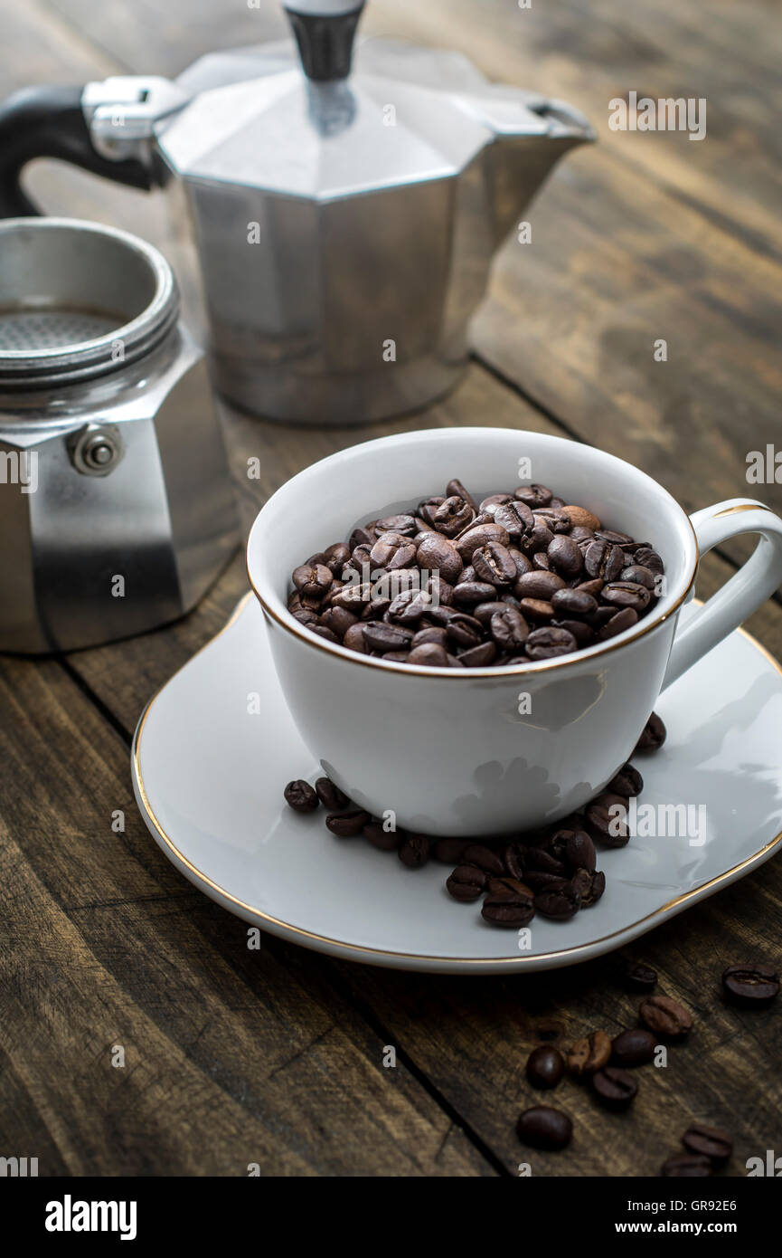 Coppa piena di chicchi di caffè sullo sfondo di legno Foto Stock