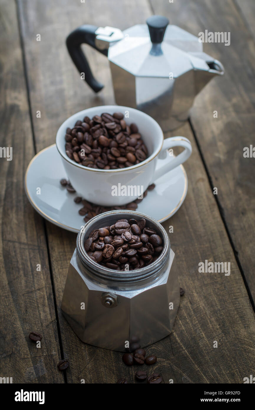 Coppa piena di chicchi di caffè sullo sfondo di legno Foto Stock