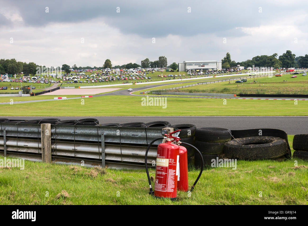 Un paio di estintori Red Fire accanto a una barriera anti-urto al circuito automobilistico di Oulton Park vicino a Tarporley Cheshire Inghilterra Regno Unito Foto Stock