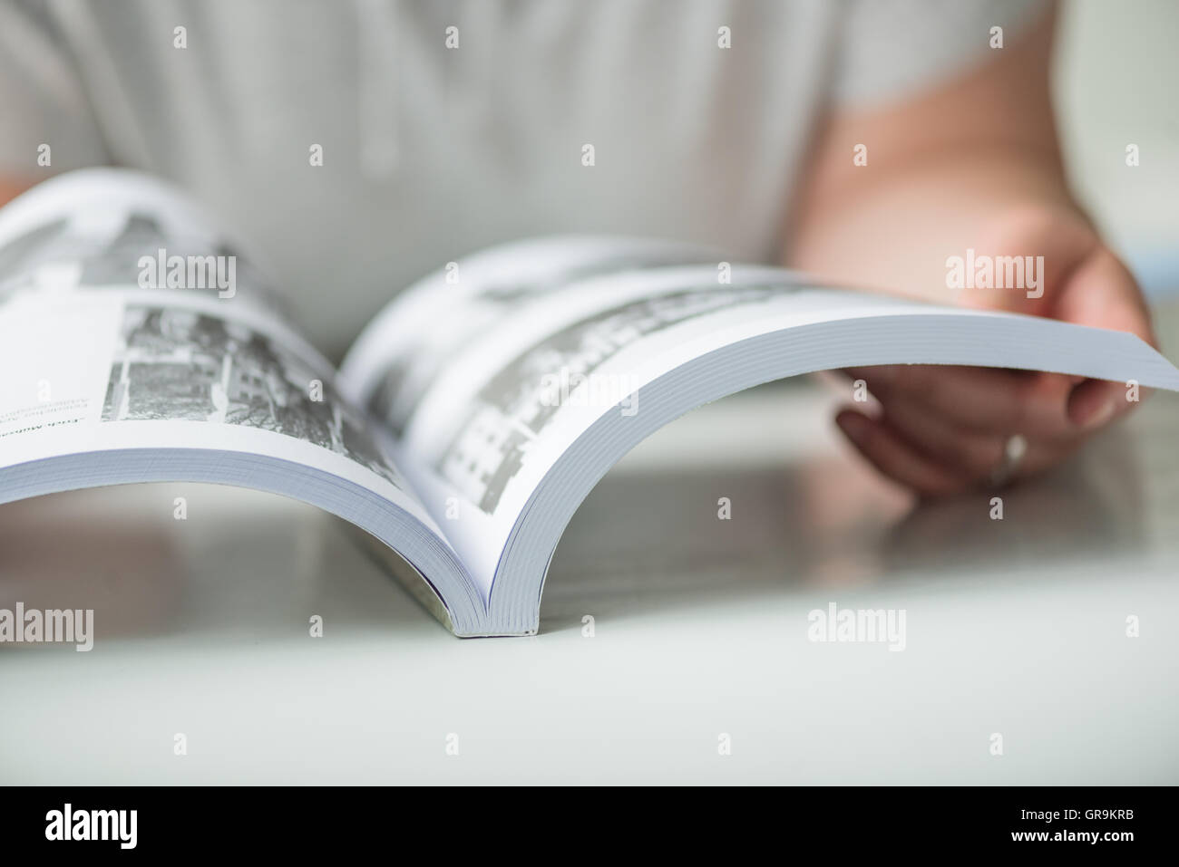 Prenota con rilegatura con copertina morbida e le mani Foto Stock