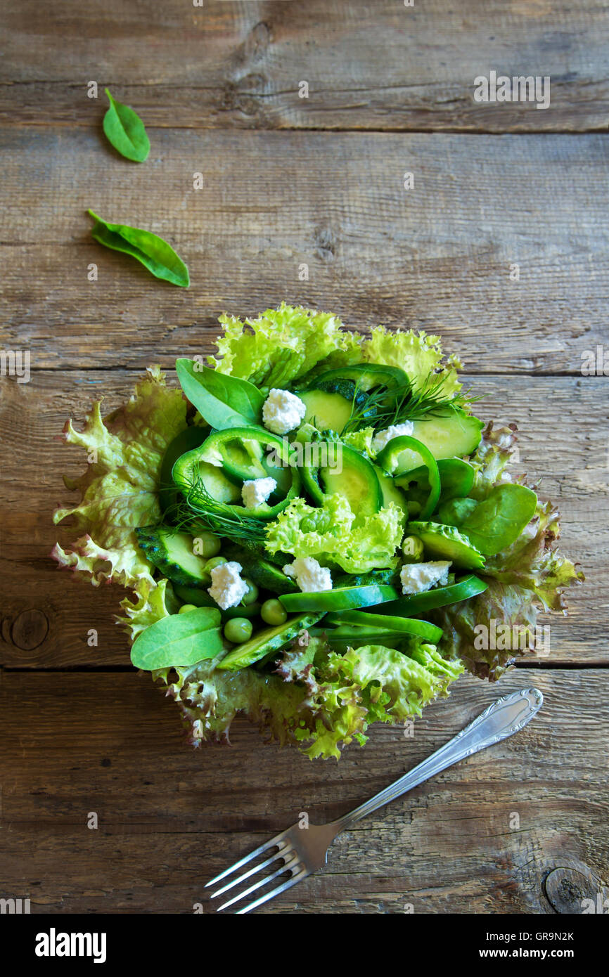 Organico verde mista insalata di verdure con formaggio feta in ciotola di legno vicino fino Foto Stock
