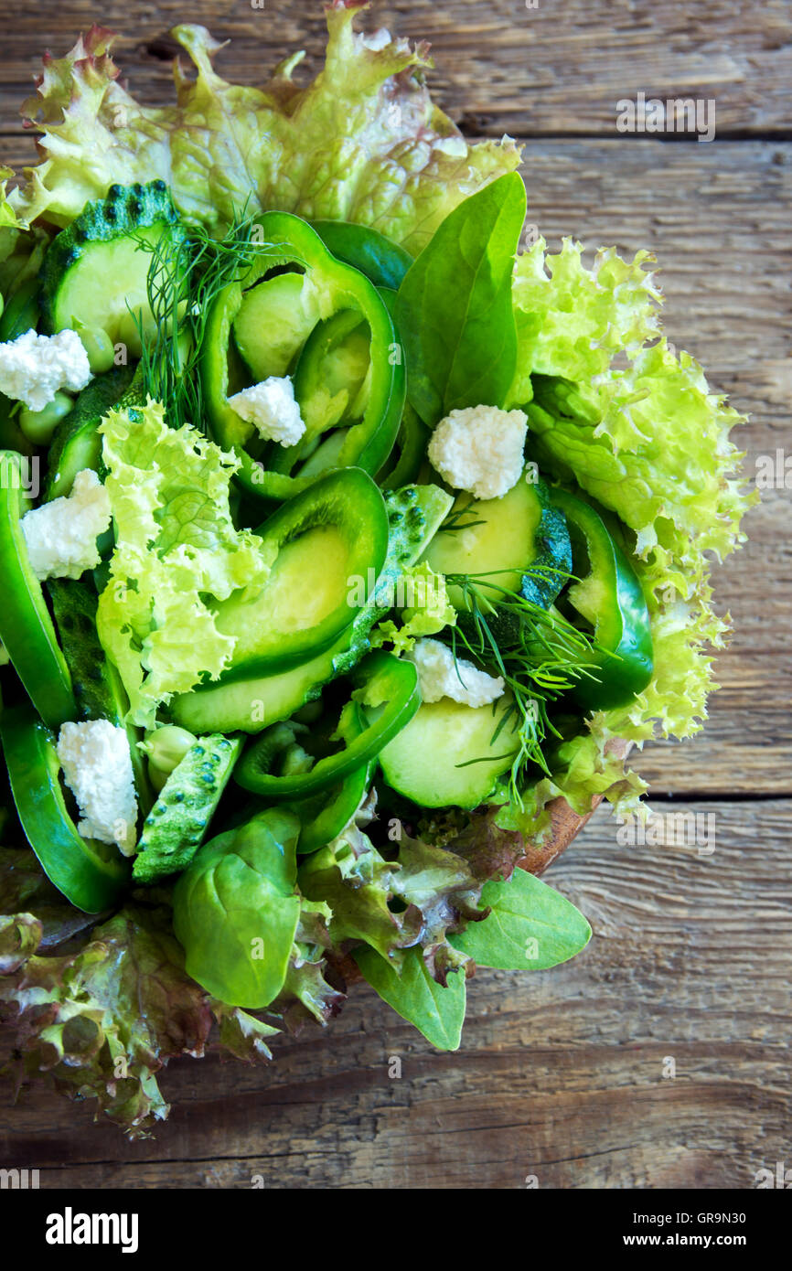 Organico verde mista insalata di verdure con formaggio feta in ciotola di legno vicino fino Foto Stock