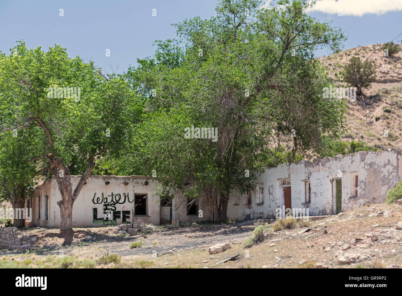 Sunrise molle, Arizona - un edificio abbandonato nella Riserva Navajo porta lo slogan, "l'acqua è vita". Foto Stock
