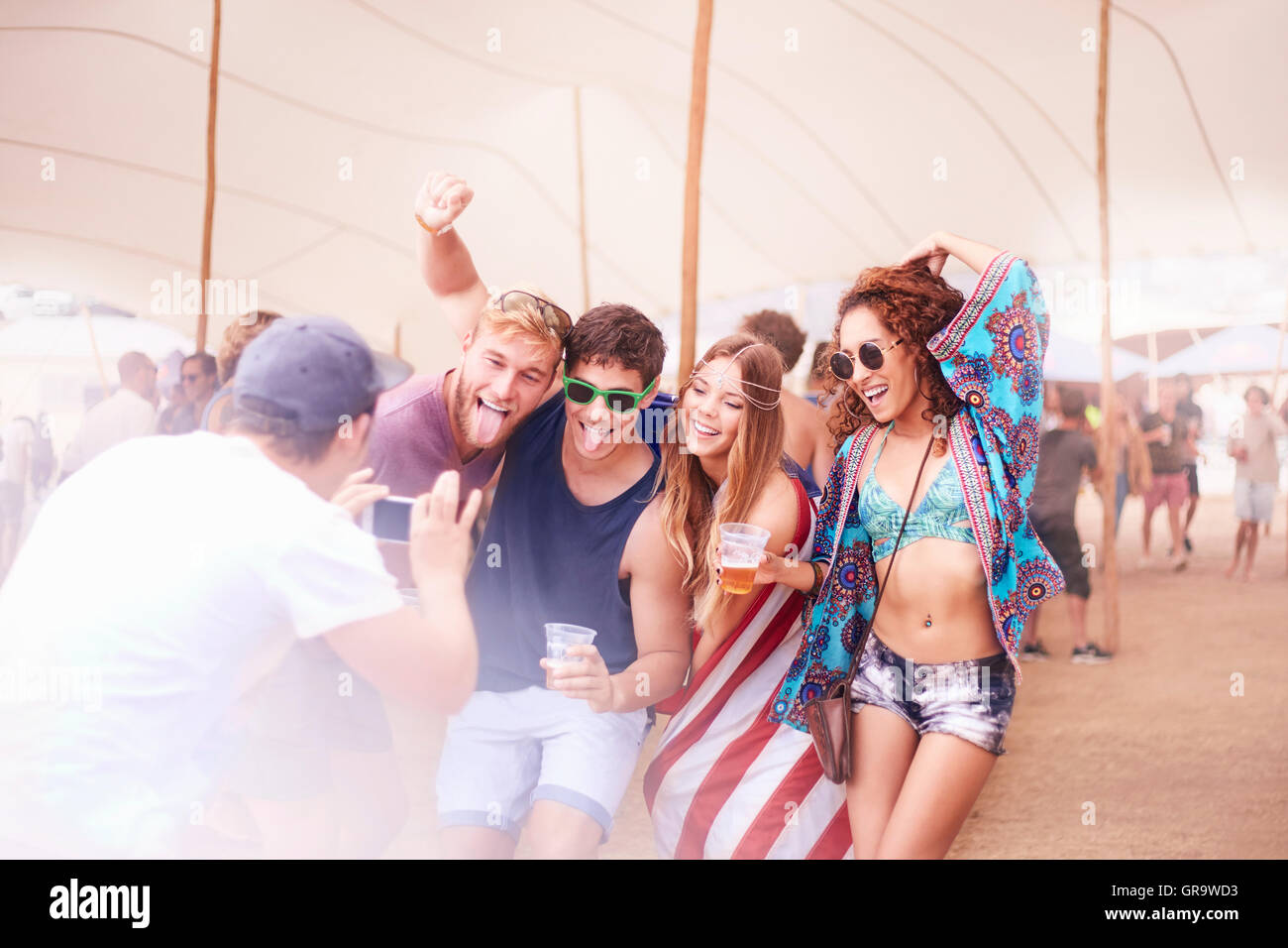 Giocoso giovani amici con la birra in posa per telefono con fotocamera al festival di musica Foto Stock