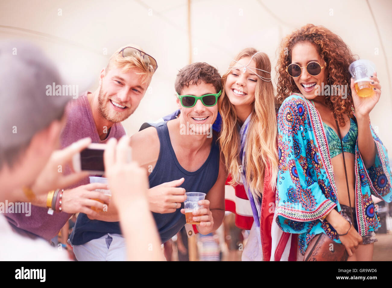 Giovani amici con la birra in posa per telefono con fotocamera al festival di musica Foto Stock