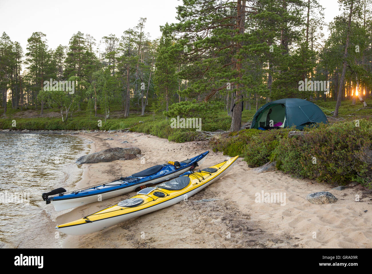 Due kayak da mare e una tenda sulla riva del lago Inari nel nord della Lapponia in Finlandia Foto Stock