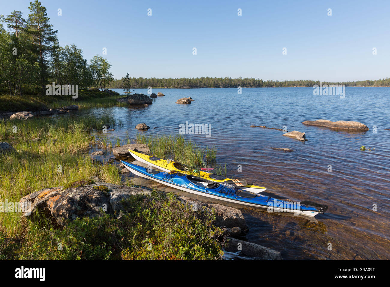 Due kayak da mare sulla riva del lago Inari nel nord della Lapponia in Finlandia Foto Stock