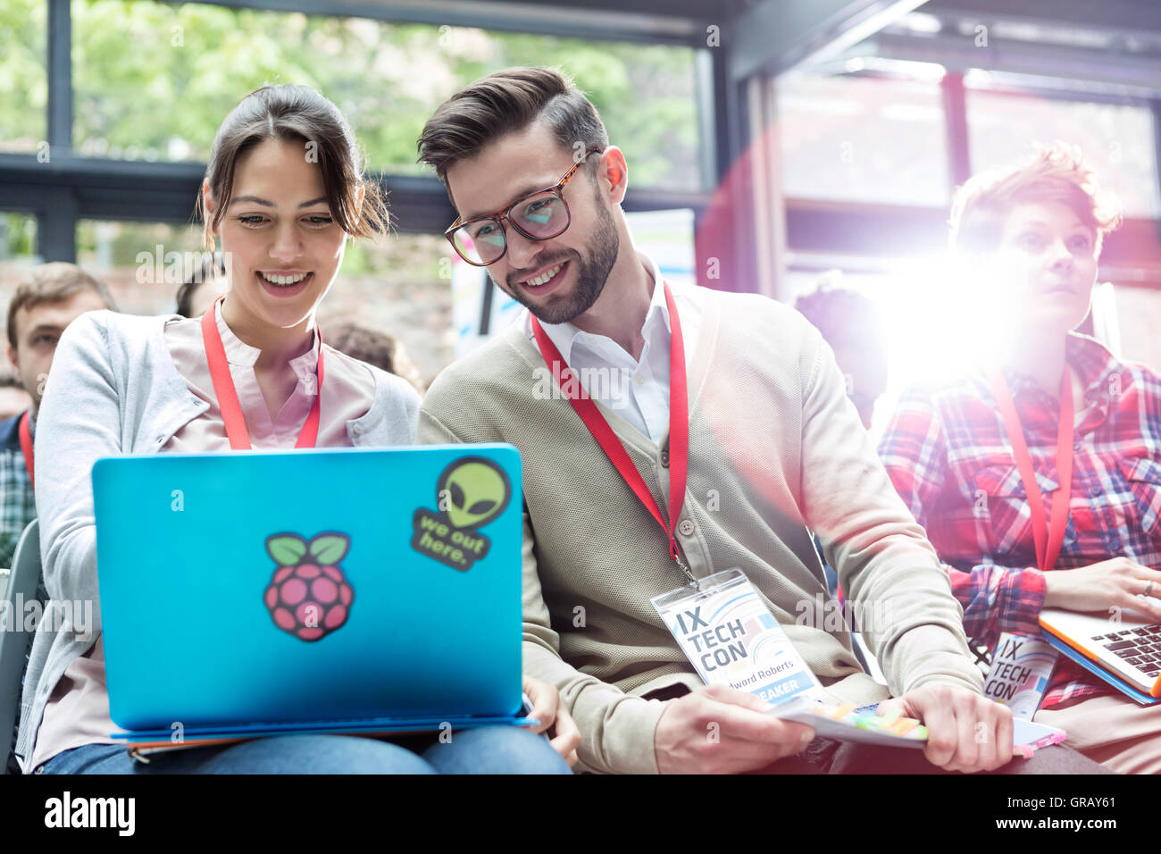 Uomo e donna che utilizza computer portatile in pubblico alla conferenza della tecnologia Foto Stock