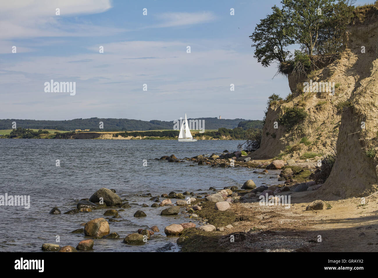 Shore scarpata a Reddevitzer Höft con imbarcazioni a vela bianca sullo sfondo la torre di The Hunting Lodge Granitz Foto Stock