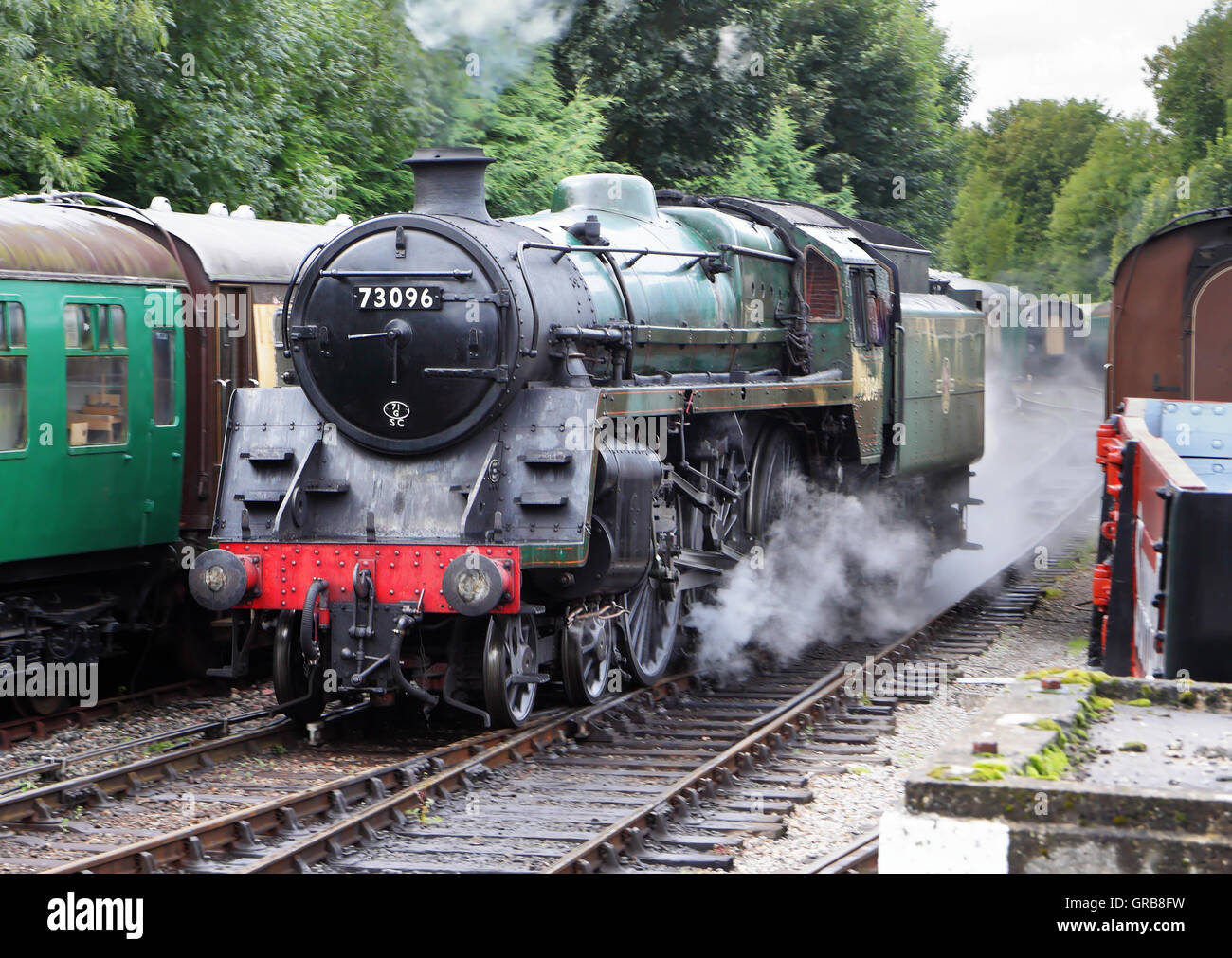 Cottura a vapore locomotiva lungo i binari ferroviari in Inghilterra Foto Stock