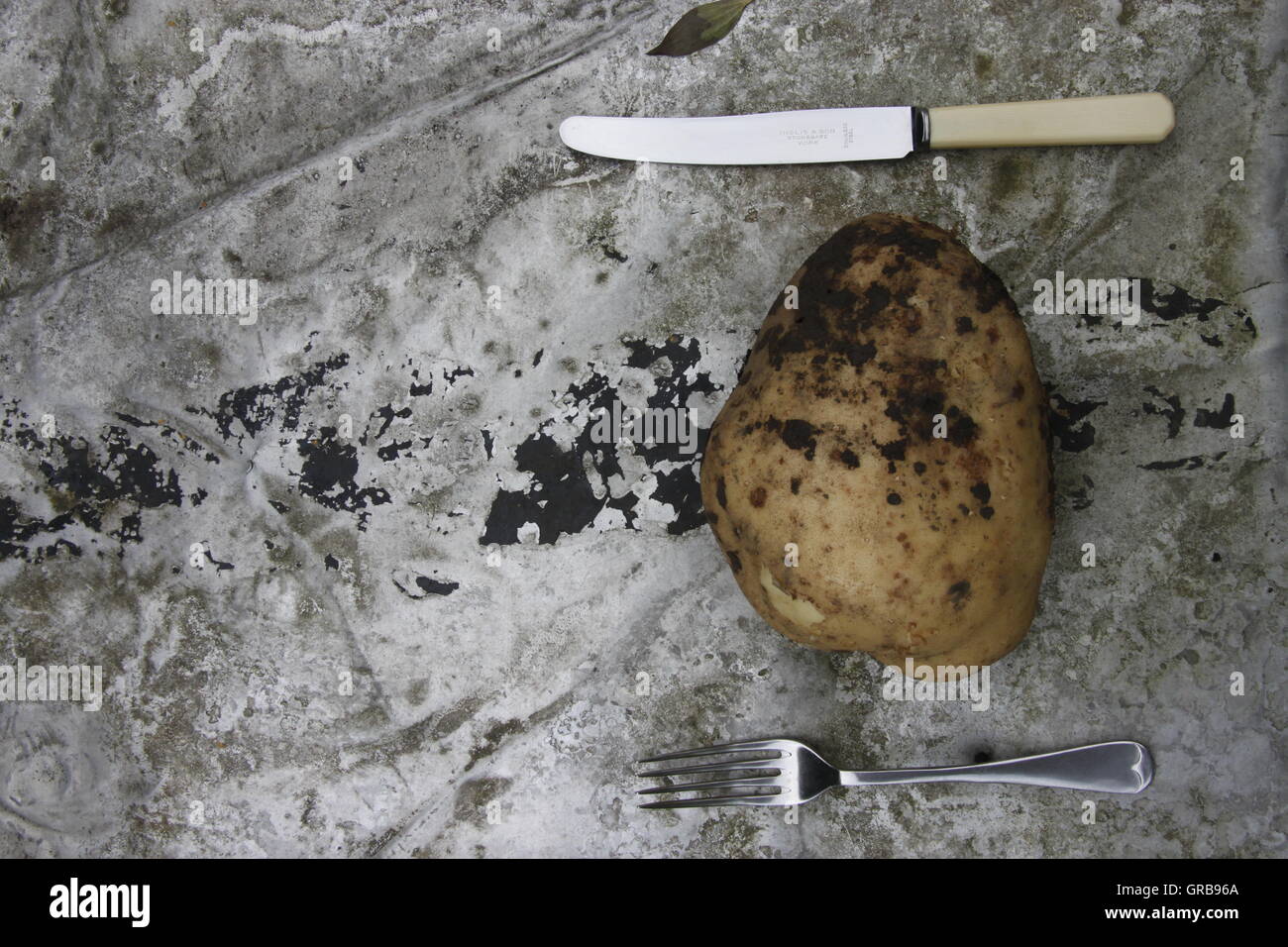 Grande casa di patate coltivate con il coltello e la forchetta sul tavolo da giardino Beverley, Yorkshire cibo sano da ripartirsi. Foto Stock