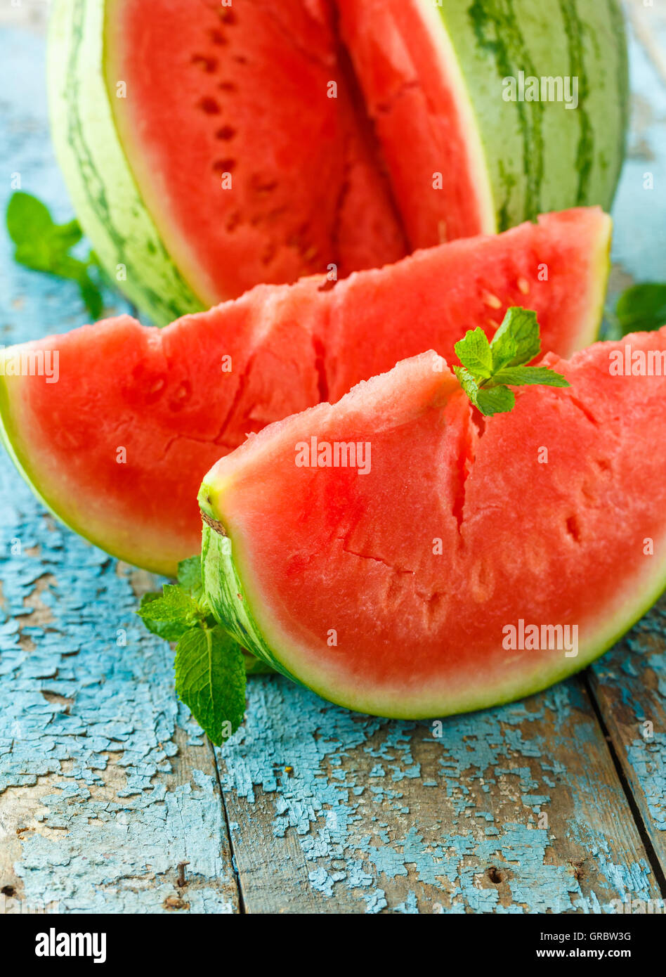 Anguria fresco tagliato a fette con la menta vicino sul tavolo Foto Stock