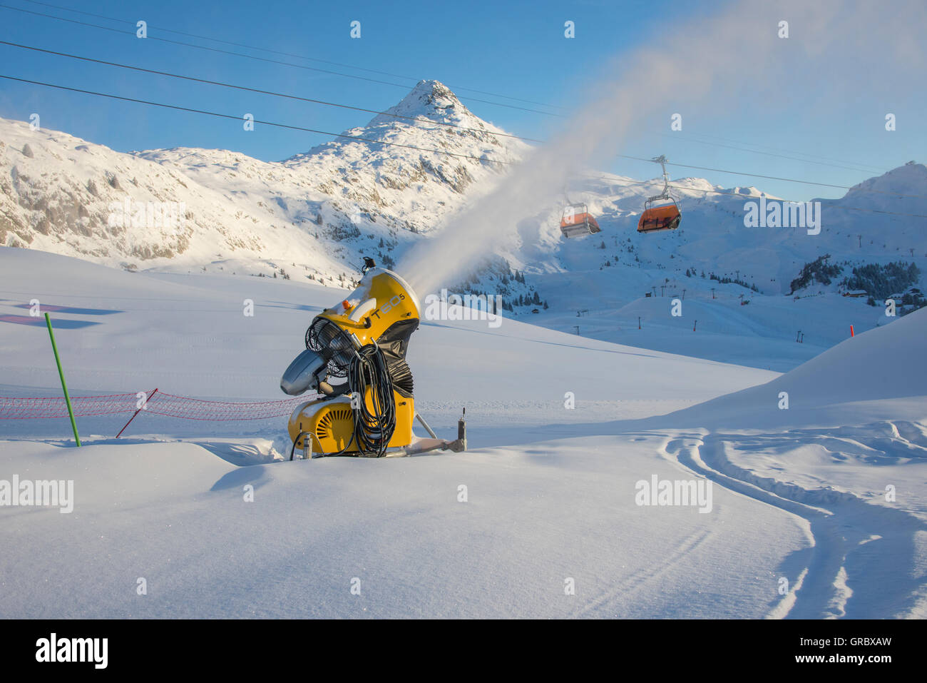 Snowfield con Active giallo cannoni da neve, in background e Bettmerhorn cielo blu Foto Stock