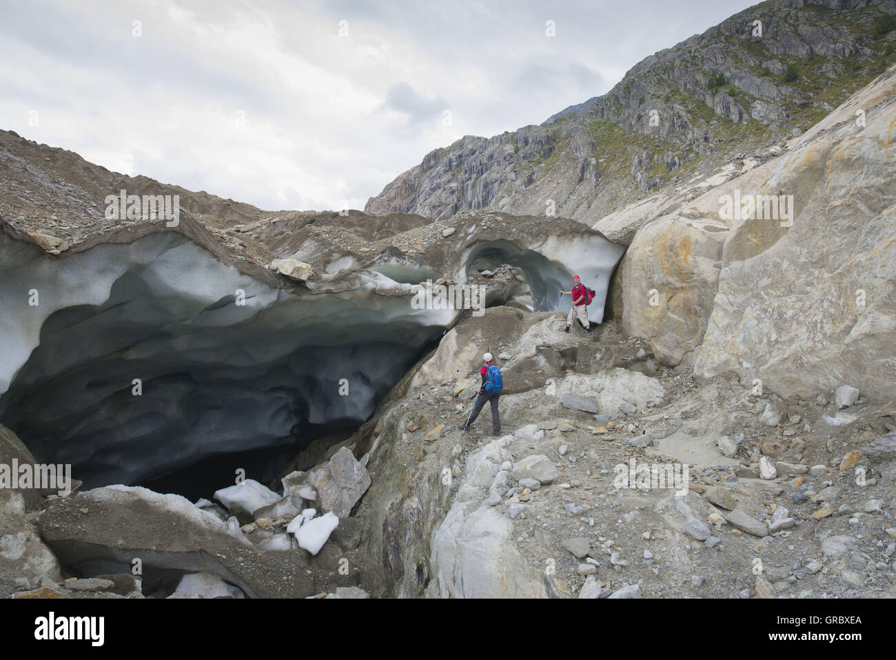 Due alpinisti 2 sta cercando in un parzialmente crollata la grotta del ghiacciaio Foto Stock