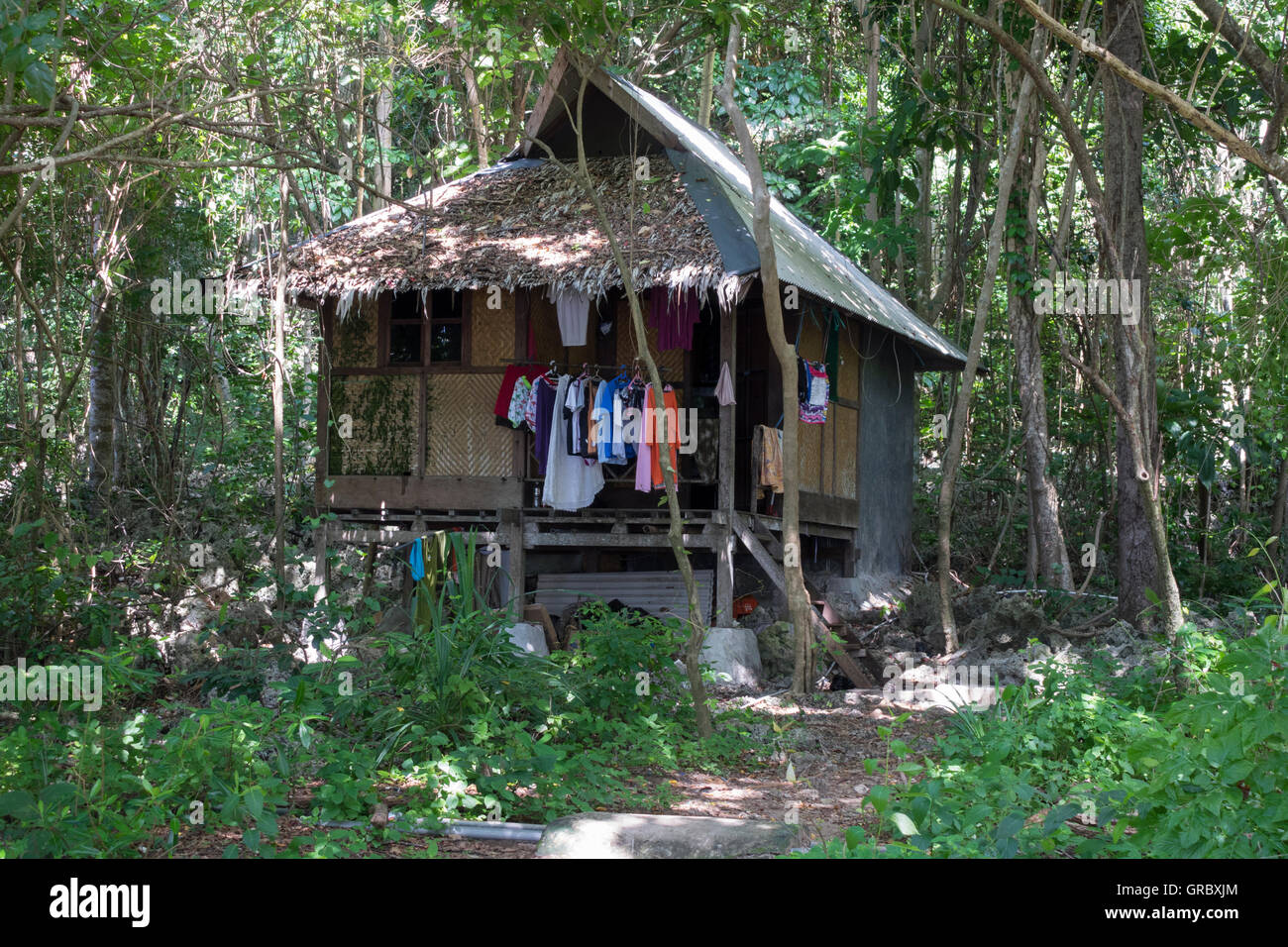 Casa indonesiano in stile tradizionale circondato da lussureggiante vegetazione tropicale, Selayar, Sulawesi meridionale, Indonesia Foto Stock