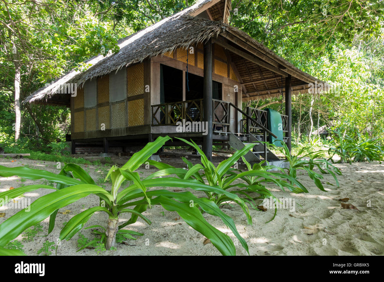 Bungalow in stile tradizionale circondato da vegetazione tropicale. Selayar, Sulawesi meridionale, Indonesia. Foto Stock