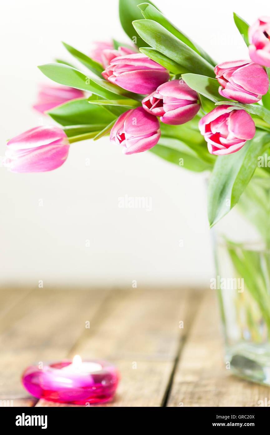 Viola i tulipani in un vaso sul vecchio tavolo in legno Foto Stock