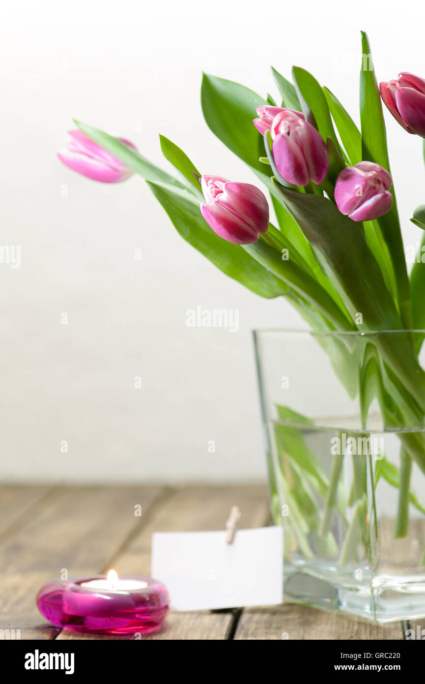 Viola i tulipani in un vaso sul vecchio tavolo in legno Foto Stock