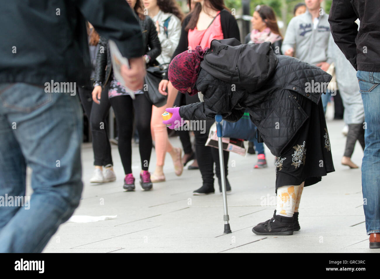 Anziana donna senzatetto di accattonaggio in pubblico Foto Stock