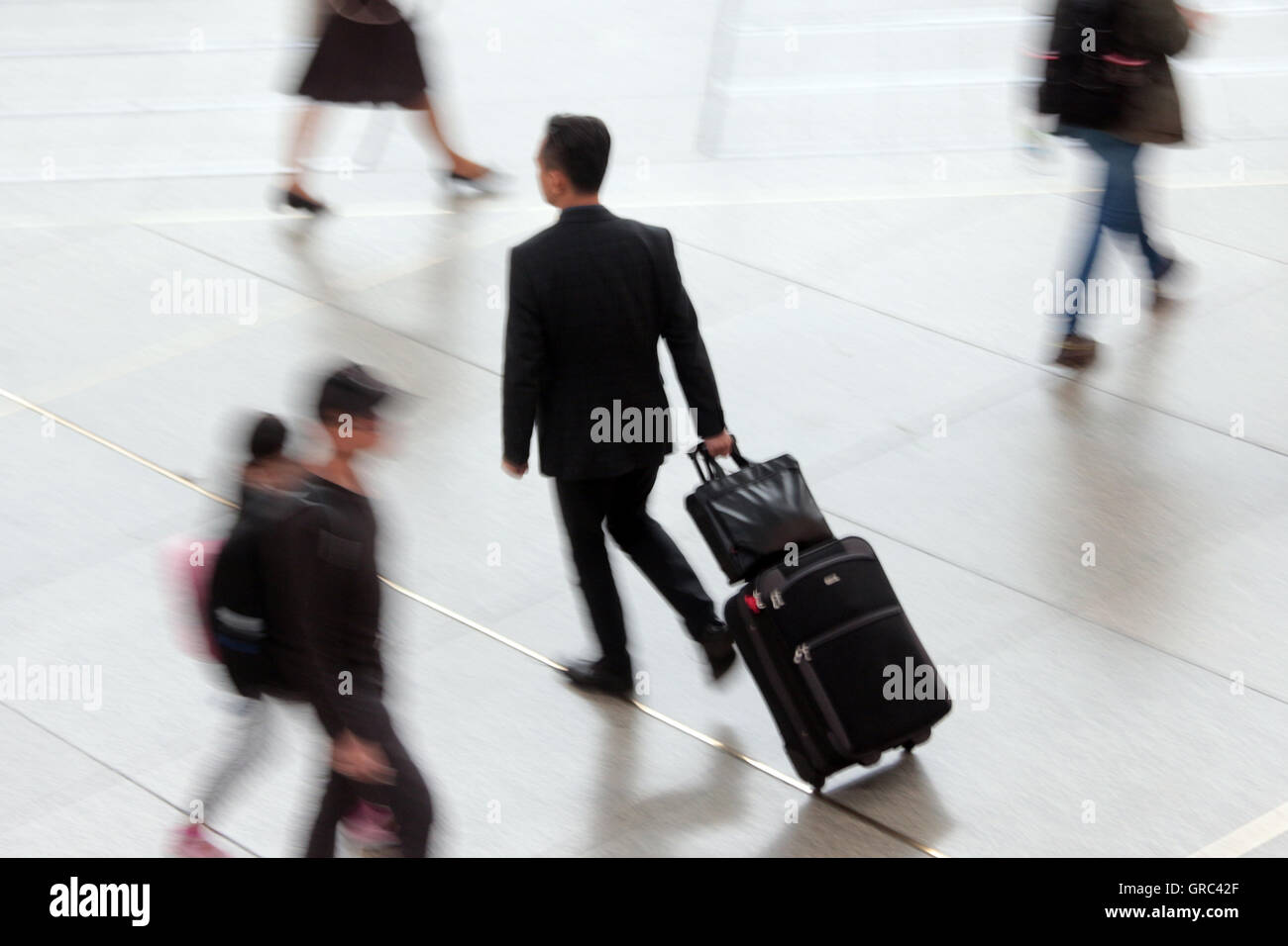 Viaggiatori di affari con i bagagli Hurries Foto Stock