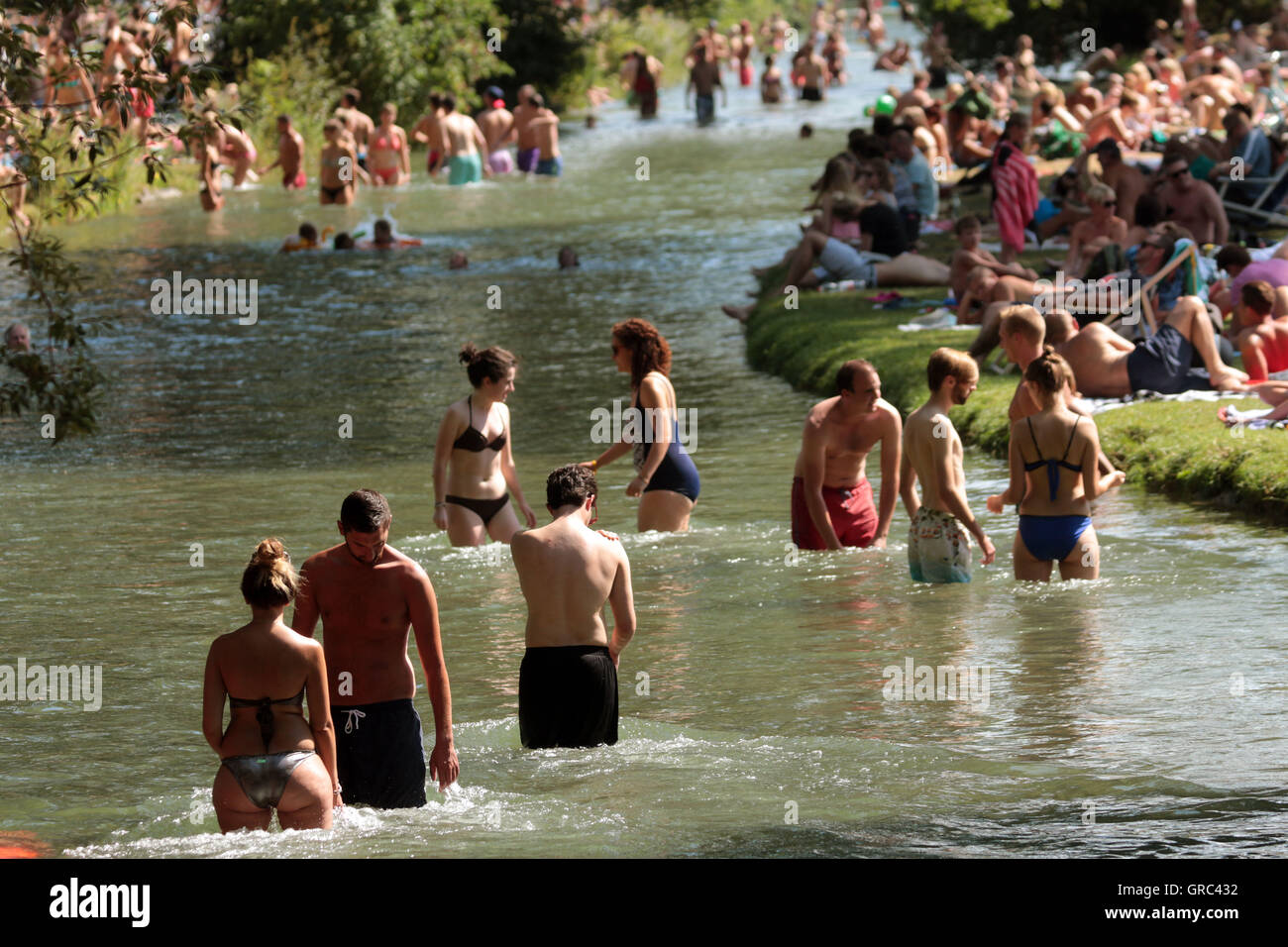 Affollato di Prato e Eisbach durante l'ondata di caldo in Englischer Garten a Monaco di Baviera Foto Stock