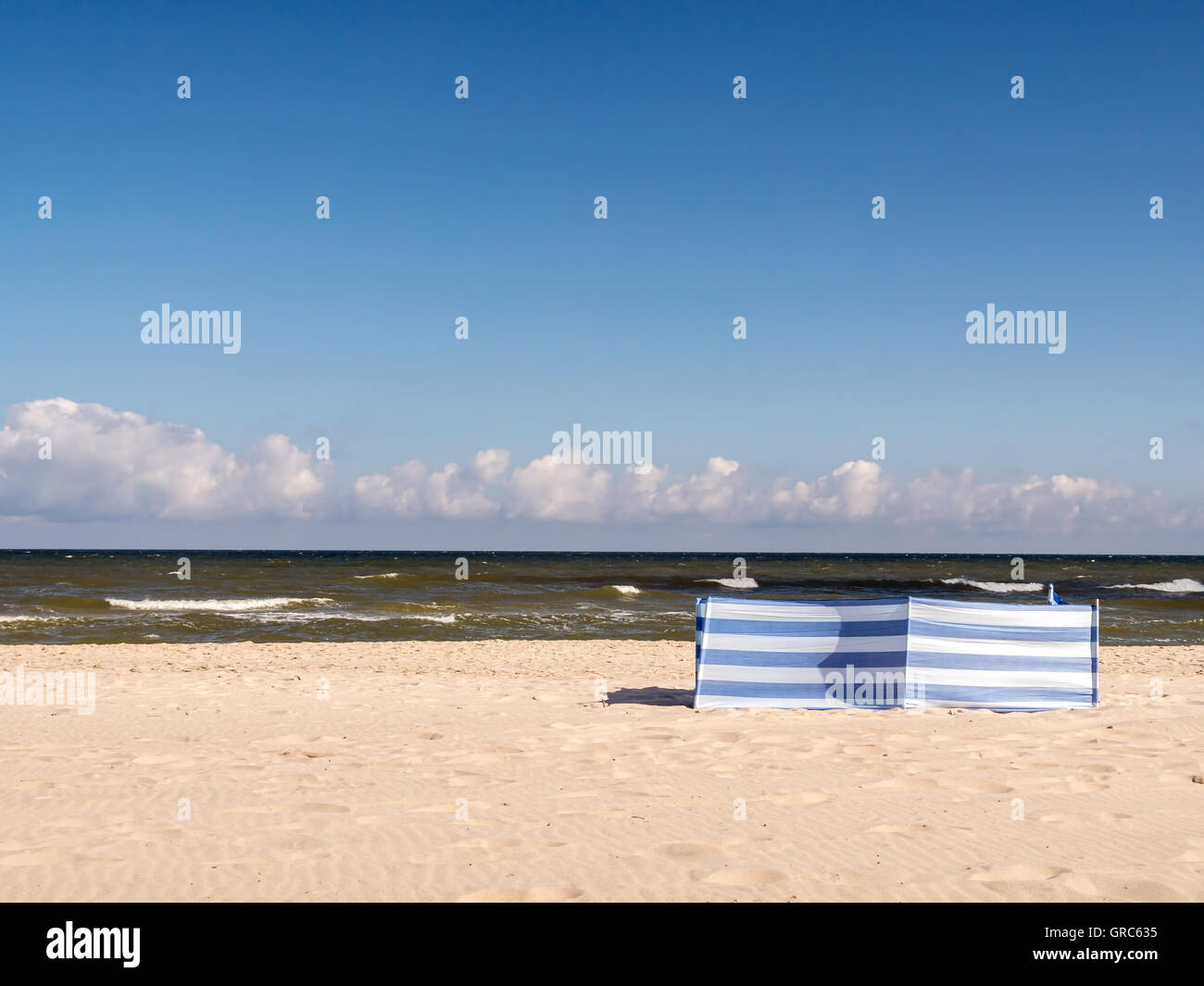 Bianco e blu frangivento a strisce in spiaggia Foto Stock
