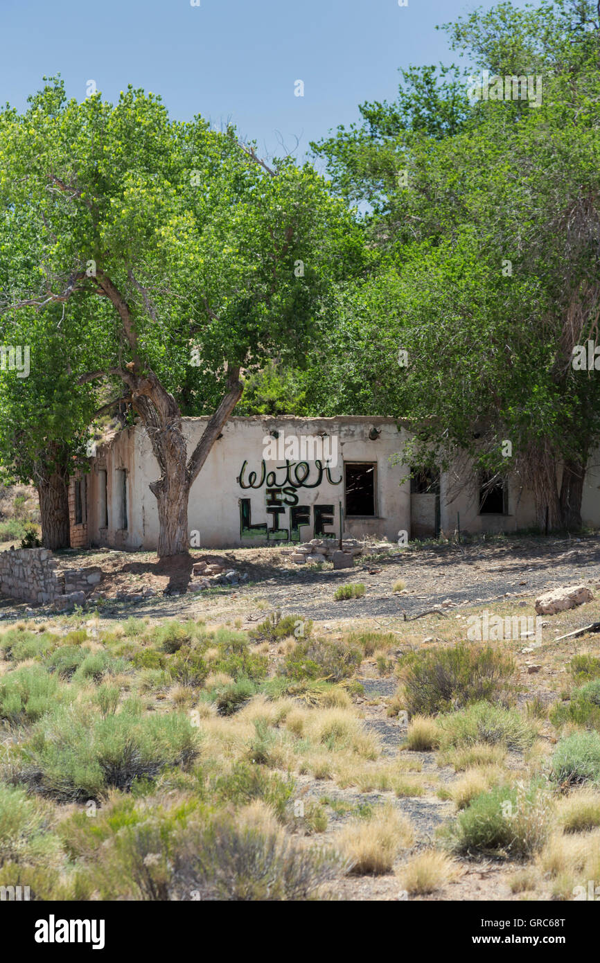Sunrise molle, Arizona - un edificio abbandonato nella Riserva Navajo porta lo slogan, "l'acqua è vita". Foto Stock