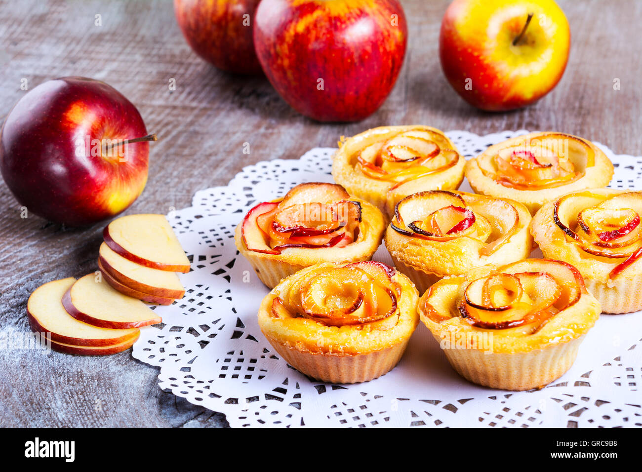 Apple rose a forma di muffin su tavola in legno rustico. Dolce dessert apple pie. In casa apple pasticceria Rosa. Foto Stock