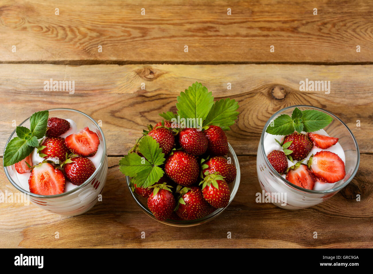 Fragole stratificata dieta yogurt dessert su sfondo di legno. Estate con dessert freschi fragole mature. Foto Stock