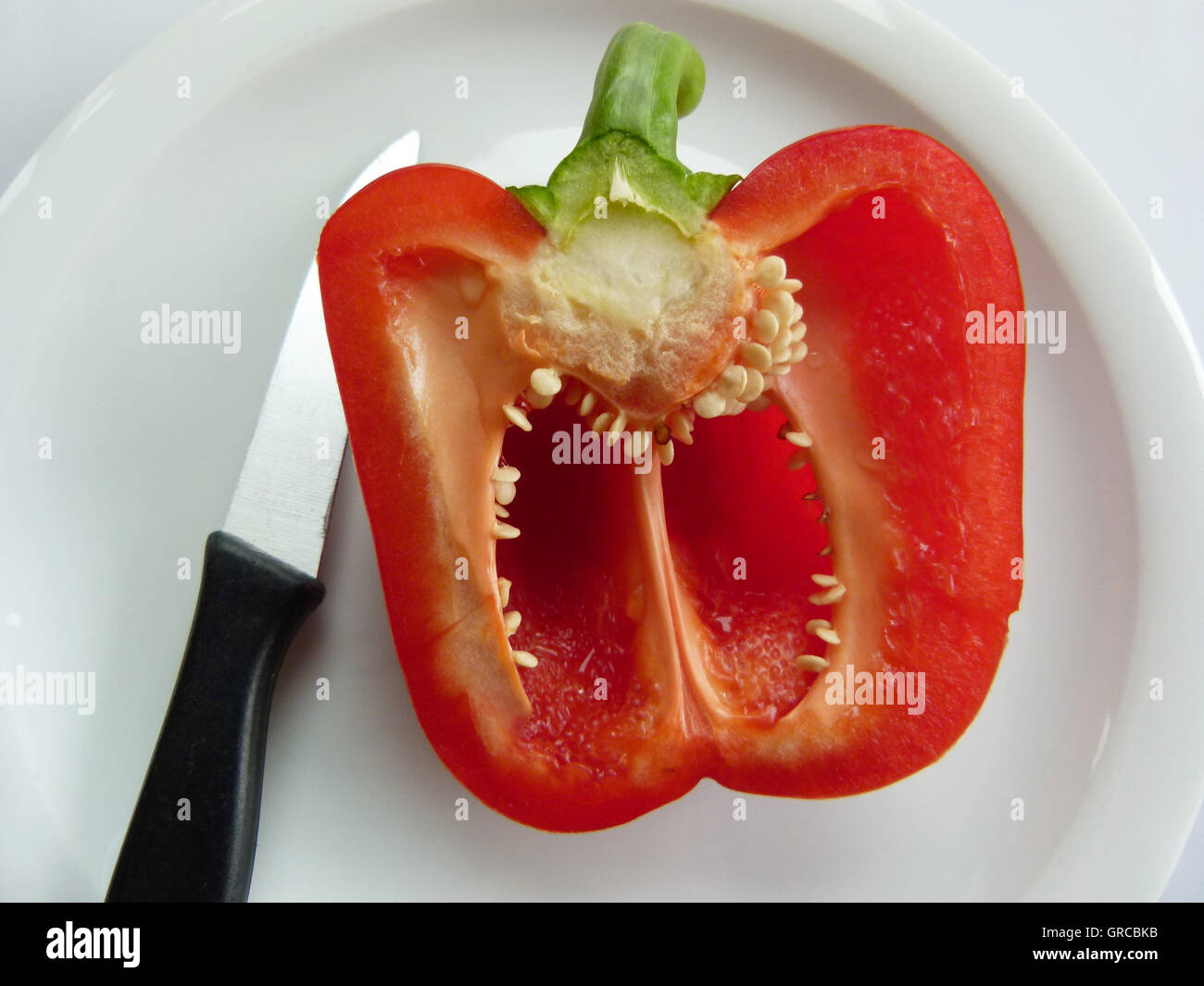 Tagliate a metà il peperone su una piastra, DIETA Foto Stock