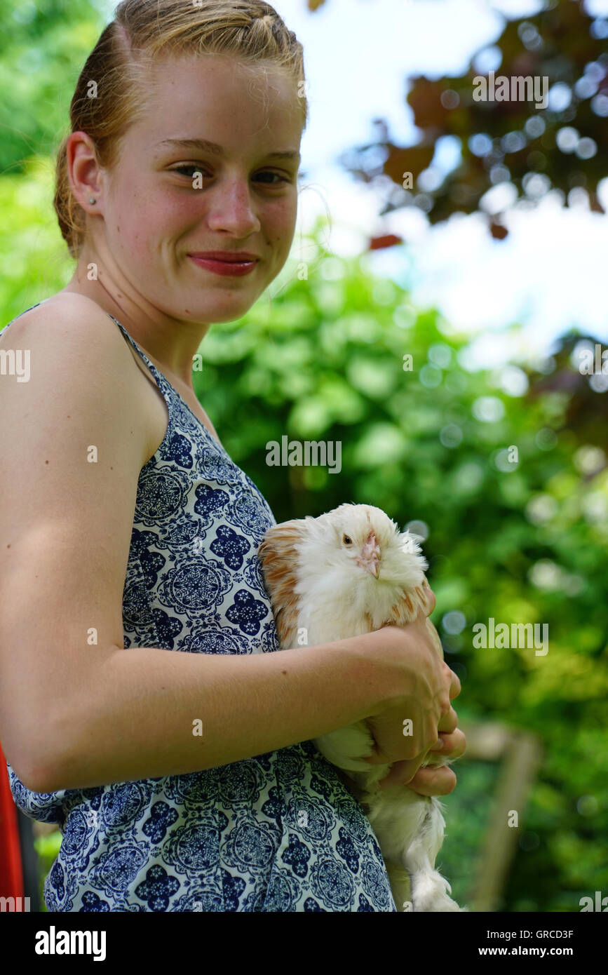 Ragazza trattiene il suo pollo nelle sue braccia, Tedesco il pollo di salmone Foto Stock