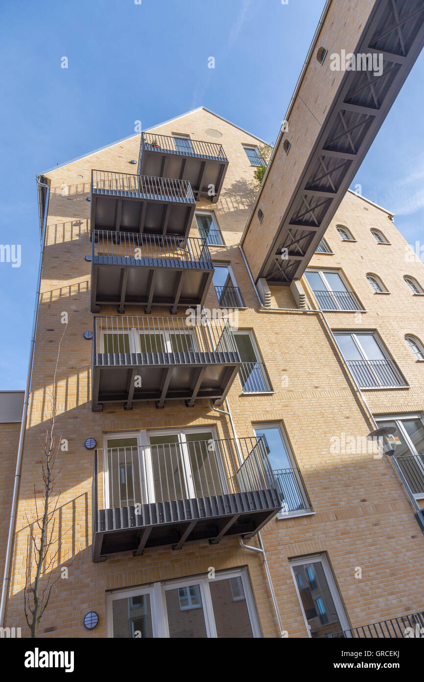 Giallo casa di mattoni con un ponte e balconi Foto Stock