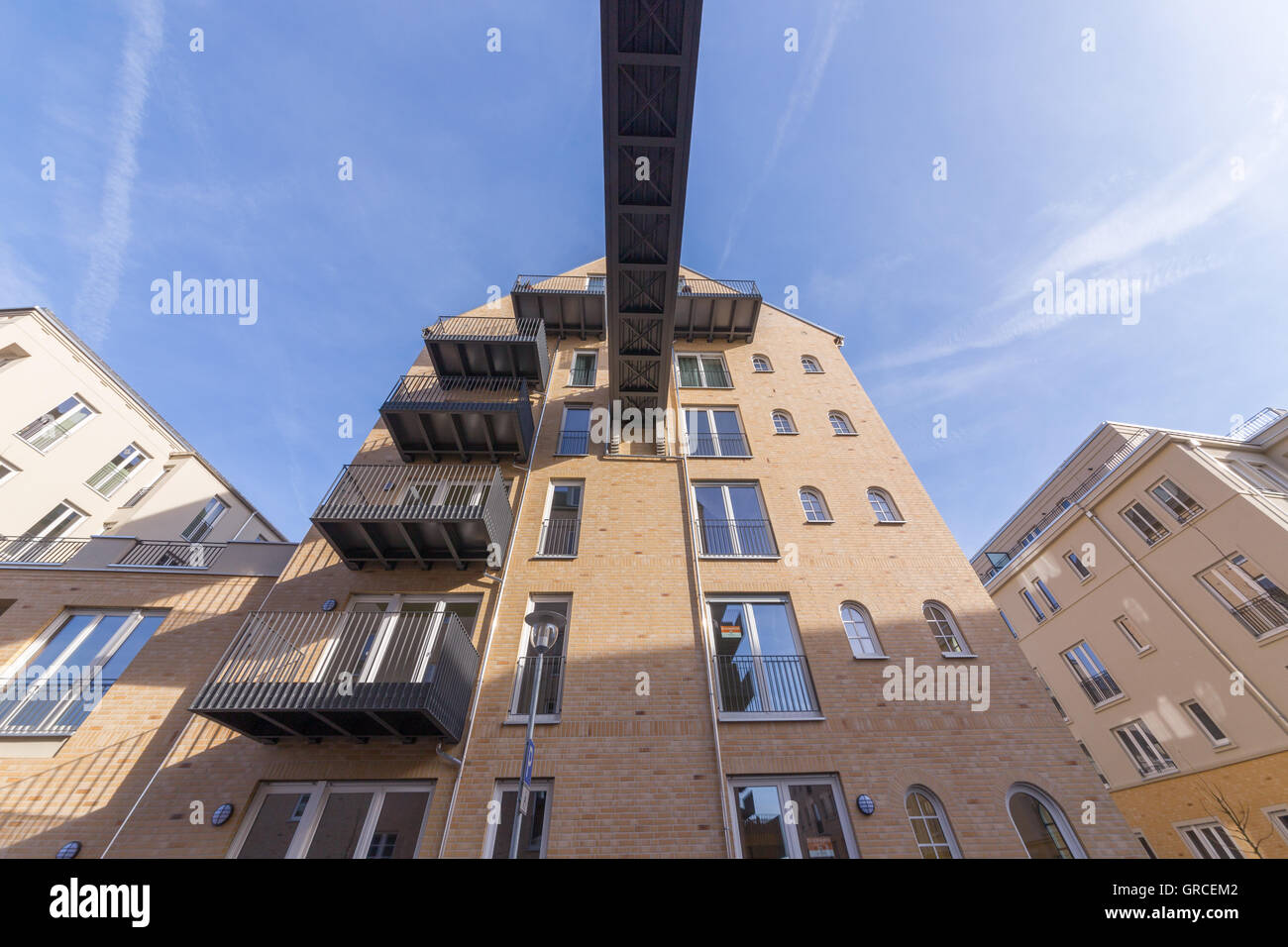 Giallo casa di mattoni con un ponte e balconi Foto Stock