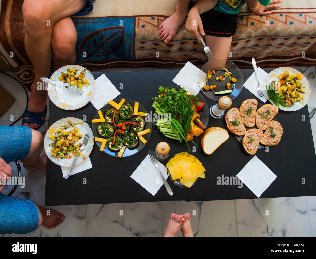 Vista superiore della festa di famiglia vicino a una tabella con una varietà di piatti laterali Foto Stock