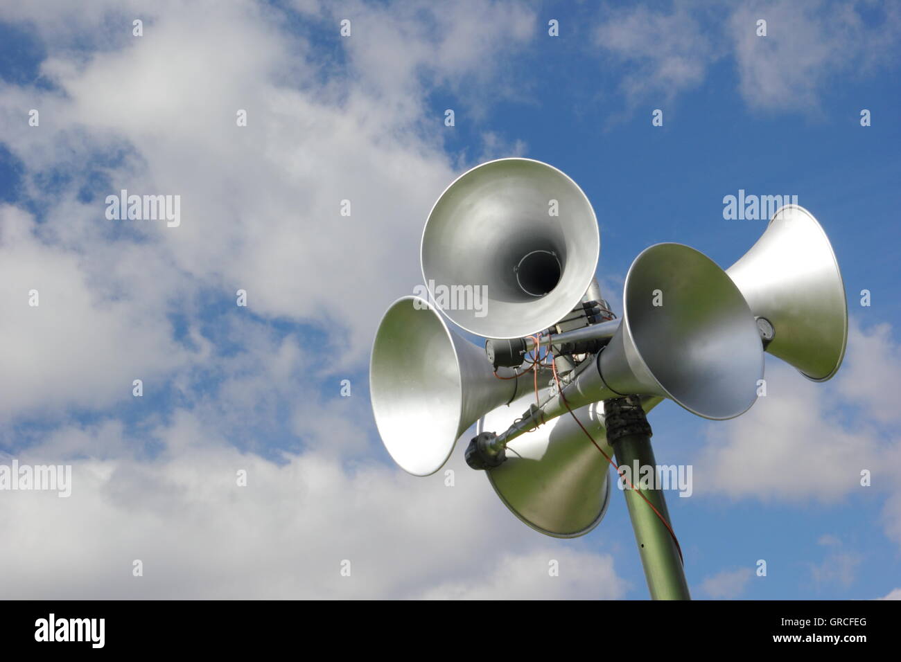 Altoparlanti su un sistema di comunicazione al pubblico contro un cielo blu e nuvole. Copia dello spazio. Foto Stock