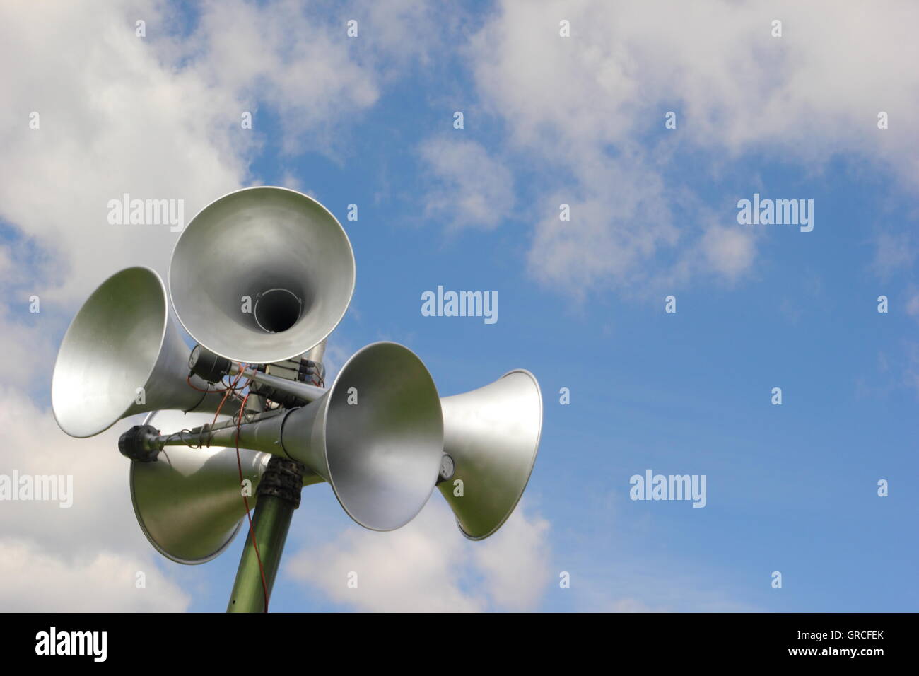 Altoparlanti su un sistema di comunicazione al pubblico contro un cielo blu e nuvole. Con copia spazio. Foto Stock