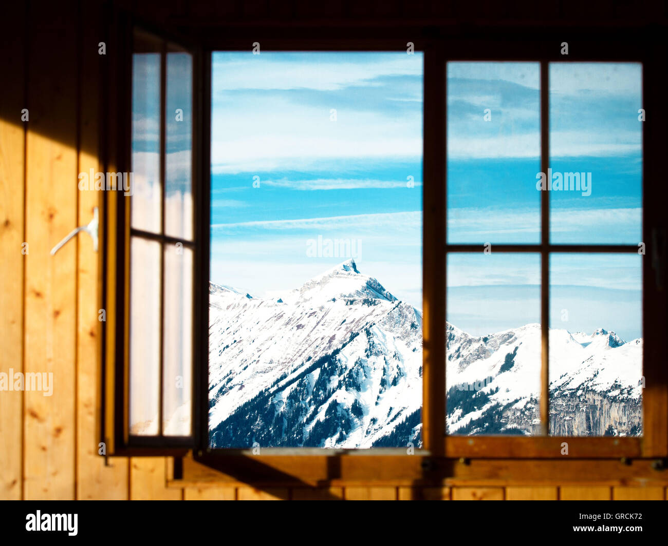 Vista attraverso una finestra di cime ricoperte di neve Foto Stock
