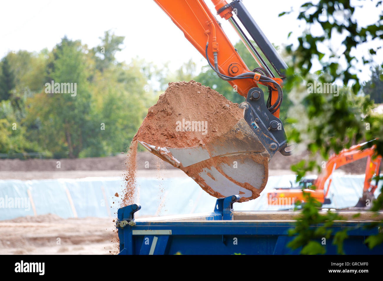 Piena pala di scavo durante il caricamento nello scavo Foto Stock