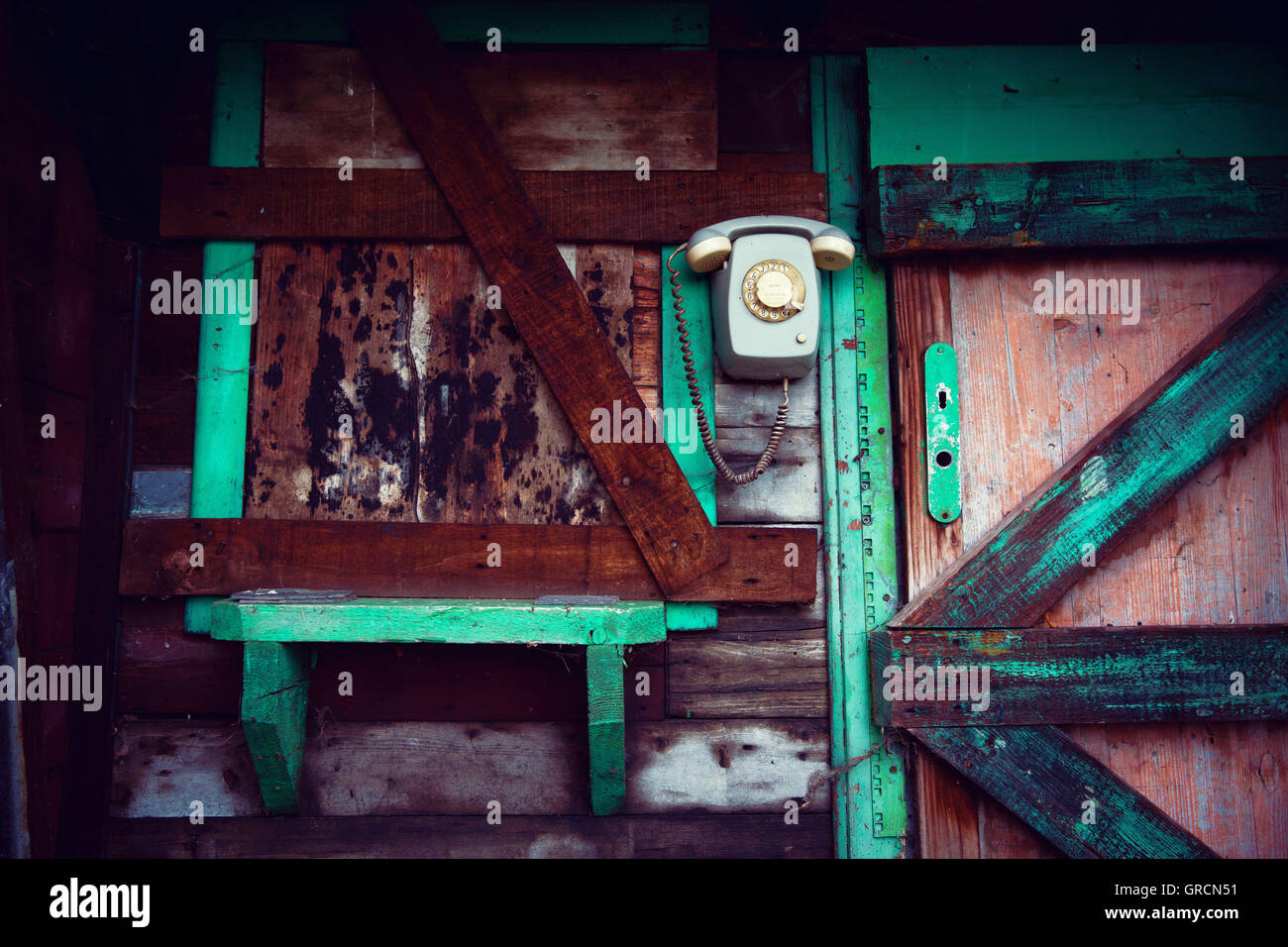 Vecchio muro telefono rotante sulla capanna in legno Foto Stock