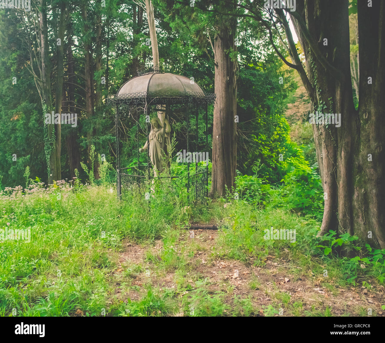 Abbandonata la statua della Madonna in un giardino Foto Stock