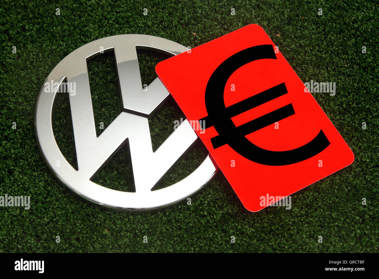 Simbolo Euro su carta rossa con Vw segno sul tappeto erboso verde Foto Stock